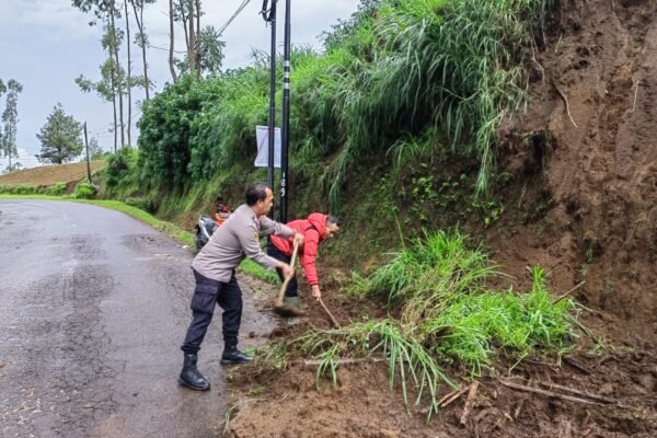 Polsek Cikajang Bersihkan Material Tanah Longsor Yang Timbun Jalan
