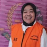 Kades cikujang, sukabumi, tersenyum lebar saat difoto memakai rompi tahanan pidsus kejari kab sukabumi, usai ditetapkan tersangka kasus korupsi dana desa, senin (28 7 2025). (tribunjabar.id m rizal jalaludin)