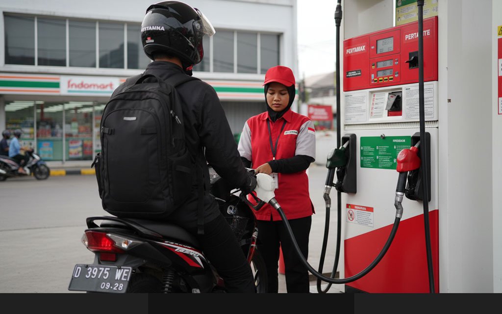 Seorang petugas SPBU sedang mengisi bensin kendaraan bermotor